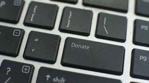 Donate button on computer keyboard, female hand fingers press key Stock Footage 97828363