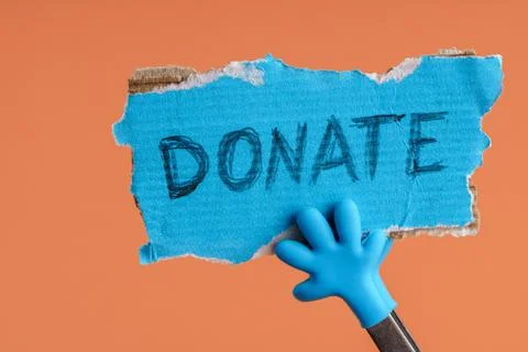 Donate message on torn cardboard Fotos de archivo