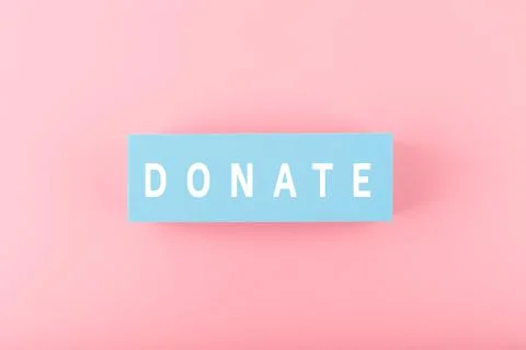 Donate modern minimal concept. Single word donate on bright pink background Stock Photos