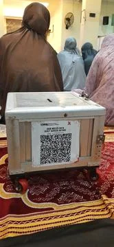 Donation Box with QR Codes on Prayer Matt in a Mosque Prayer Hall Stock Photos