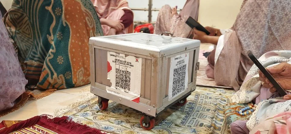 Donation Box with QR Codes on Prayer Matt in a Mosque Prayer Hall Stockfoto's