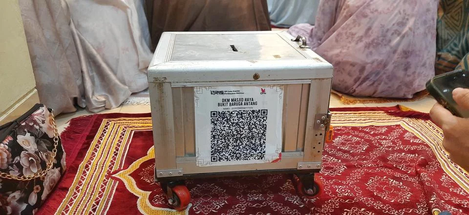Donation Box with QR Codes on Prayer Matt in a Mosque Prayer Hall Stockfoto's