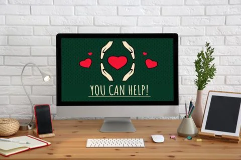 Donations concept. Computer with text YOU CAN HELP on wooden table in office Foto stock