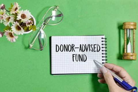 Donor-Advised Fund Concept with Notebook, Pen, and Symbolic Objects on Green Bac Stock Photos