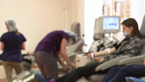 Donors donate blood while sitting in chairs. Unfocus. Video contains noises. Stock Footage 148904248