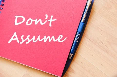 Don't assume write on notebook Stock Photos