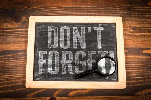 DON'T FORGET Reminder Message on Chalkboard With Magnifying Glass Stock Photos