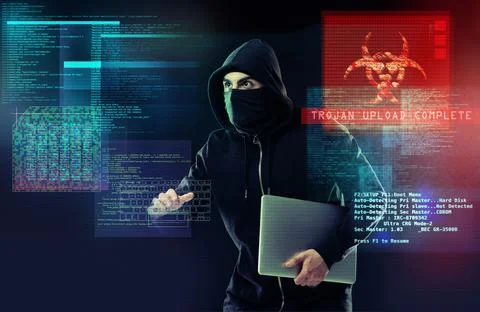 Dont let your data fall into his hands. a computer hacker holding a laptop while Stock Photos