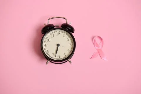 Don't miss the time, flat lay composition with an alarm clock and a pink ribb Fotos Stock
