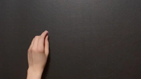 Don't panic. A left female hand writes the word by red chalk on a black board Stock Footage 127295054