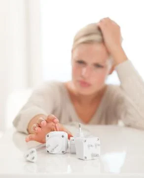 Dont pull the plug. Shot of a young woman reaching for power connection plugs Stock Photos