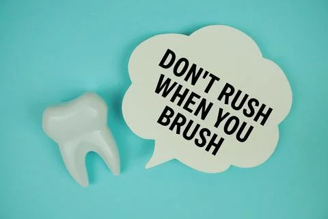 Don't Rush When You Brush text on speech bubble with white tooth model on b.. Stock Photos