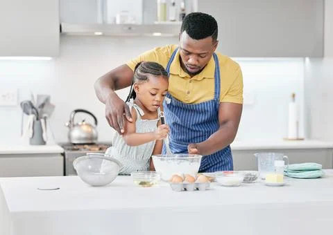 Dont whisk it so fast. a handsome young father bonding with his daughter and Stock Photos