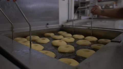 Donut Bases Being Dropped into Deep Fryer Stock Footage 139716543