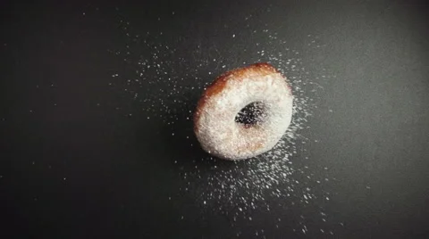 Donut falls on a black table and turn (top view) Stock Footage 62827992