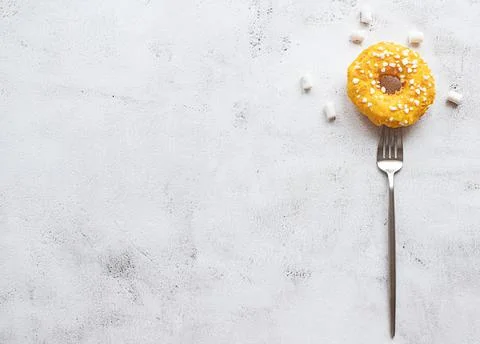 Donut on a fork, flat lay on grey background Stock Photos