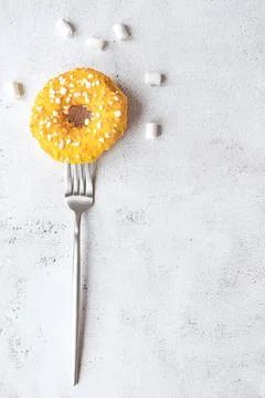 Donut on a fork, flat lay on grey background Stock Photos