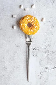 Donut on a fork, flat lay on grey background Stock Photos