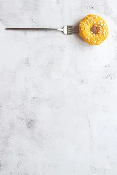 Donut on a fork, flat lay on grey background Stock Photos
