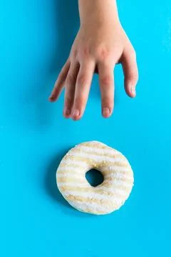 Donut with hazelnuts on blue background, close up Stock Photos