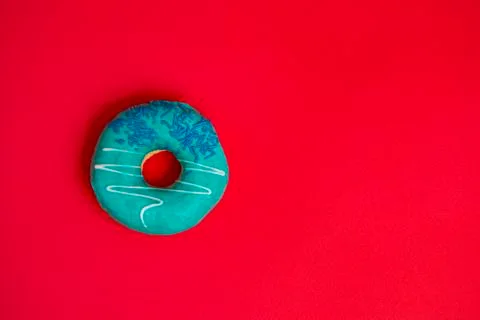Donut with mint icing on a red background Stock Photos