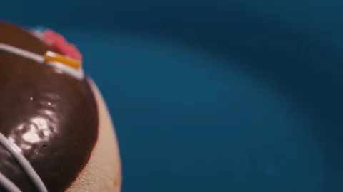 Donut rolling, close-up on a blue background 4k Stock Footage 128658825