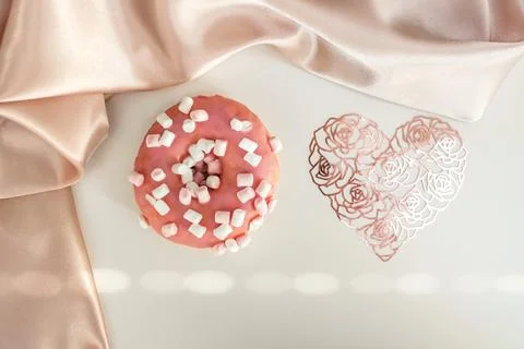 Donut with splashes, on a white background, with a lace heart and silk fabric Stock-Fotos