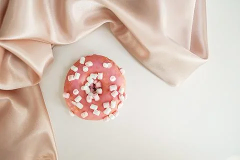 Donut with splashes, on a white background, with a silk cloth, delicate Stock Photos