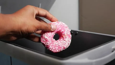 Donut is tossed into the trash can during cleanup time Stock Footage 328619477