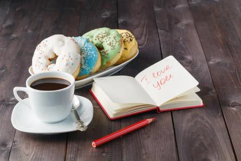 Donuts and coffee, open notebook Stock Photos