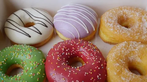 Donuts with colorful icing in a box. Stock Footage 312037982