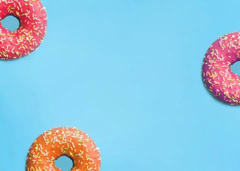 Donuts of different colors on a blue background Stock Photos