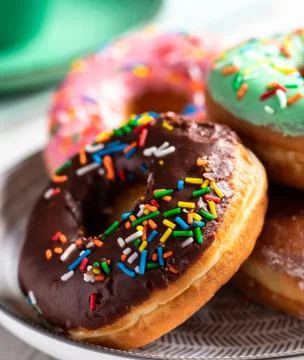 Donuts of different flavors accompanied by a cup with coffee for breakfast. Stock Photos