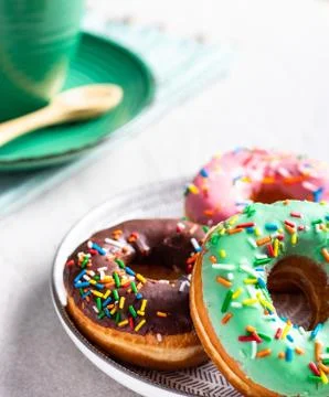Donuts of different flavors accompanied by a cup with coffee for breakfast. Stock Photos