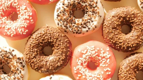 Donuts, doughnuts rotating, turning round, view from above, flat lay Stock Footage 124461657
