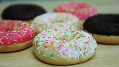 Donuts in the glaze lie on the table. Rotate the video. Stock Footage 90300064