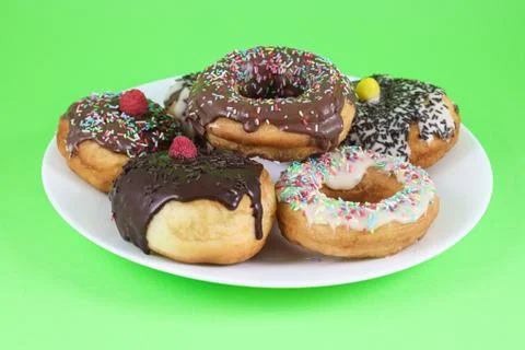 Donuts glazed with chocolate on plate Stock Photos