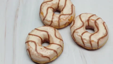 Donuts Glazed With White Icing With Brown Curls. Diagonal Dolly Slider Shot On A 스톡 동영상 150065790