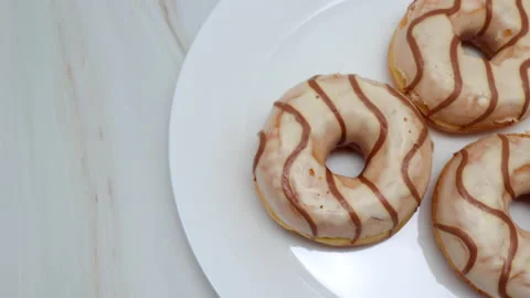 Donuts Glazed With White Icing With Brown Curls On White Plate. Diagonal Dolly S Vídeos de archivo 150066735