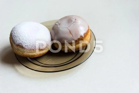 Donuts with icing and powdered sugar on a plate Stock Photos