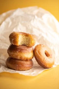 Donuts with icing on yellow background. Donuts background . Eaten donut. Stock Photos