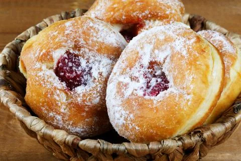 Donuts with jam in a wicker basket Stock Photos