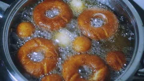 Donuts in oil close-up. 4k Stock Footage 98939646