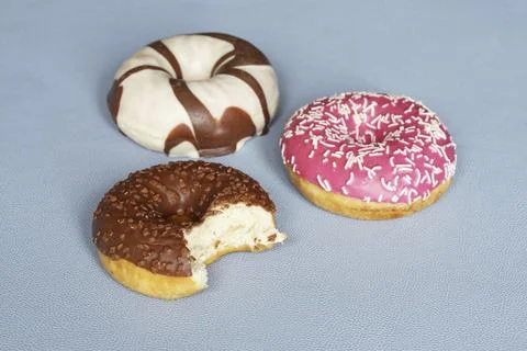 Donuts or doughnuts with different icing. chocolate donut missing a bite Stock Photos