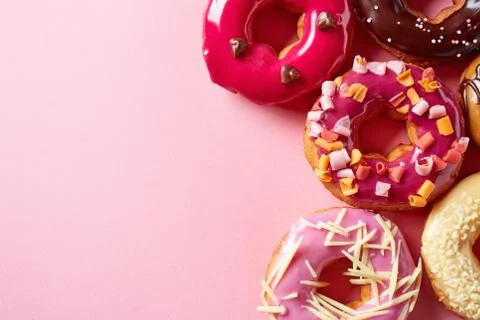 Donuts on pink background, from above Stock Photos