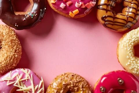 Donuts on pink background, from above Stock Photos