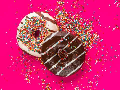 Donuts on pink background. Stock Photos