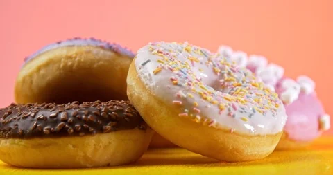 Donuts rotating on table with pink background Stockbeeldmateriaal 122178196