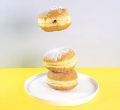 Donuts selection flying on yellow background. Various doughnuts isolated on Stock Photos