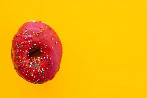 Donuts with sprinkles isolated on yellow background Stock Photos